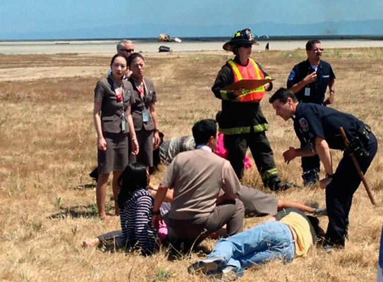 Image: File picture shows Asiana Airlines flight attendant Kim Ji-yeon standing near a runway with rescued passengers in San Francisco